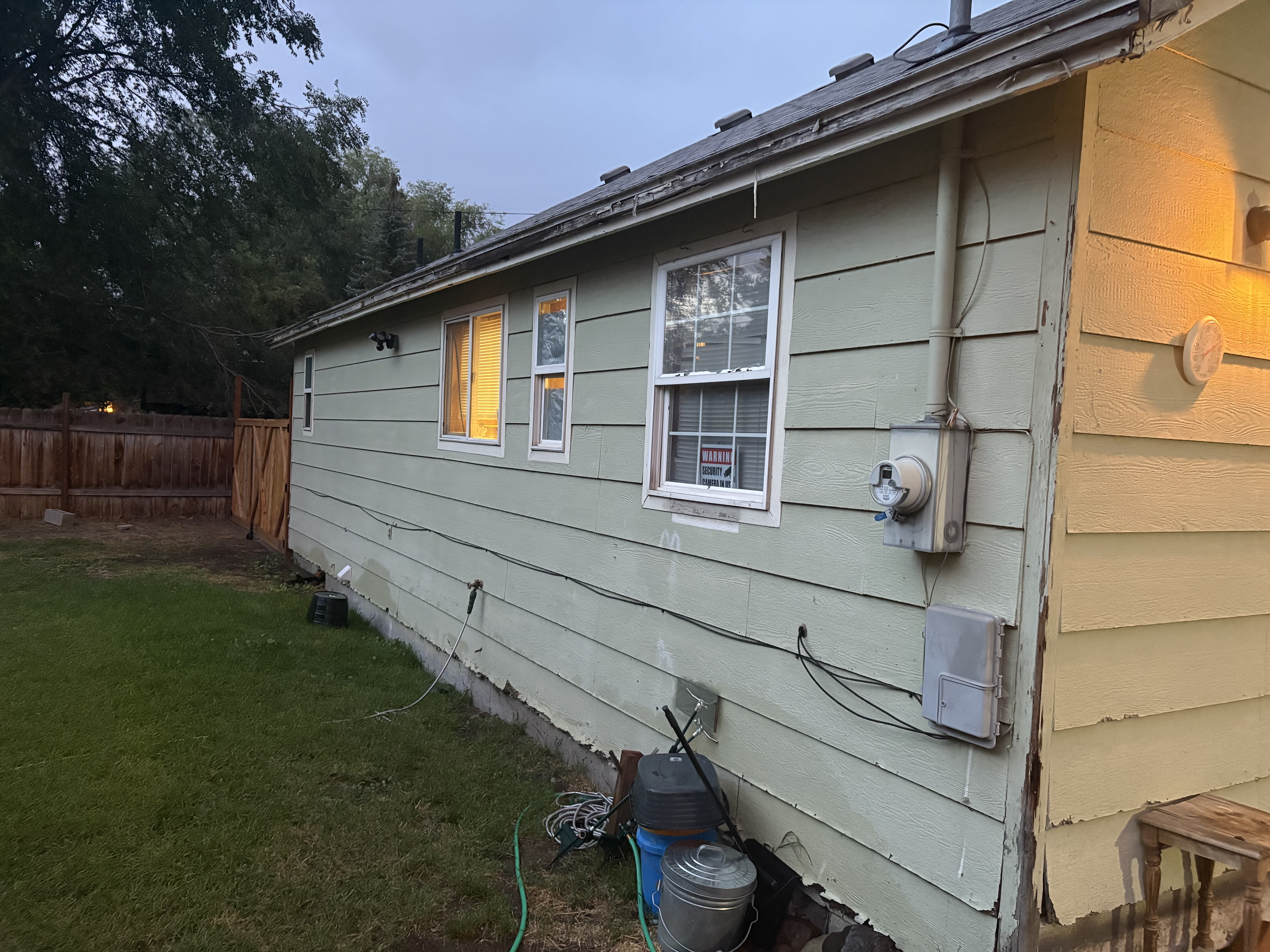 Exterior before – old lap siding at dusk, side view